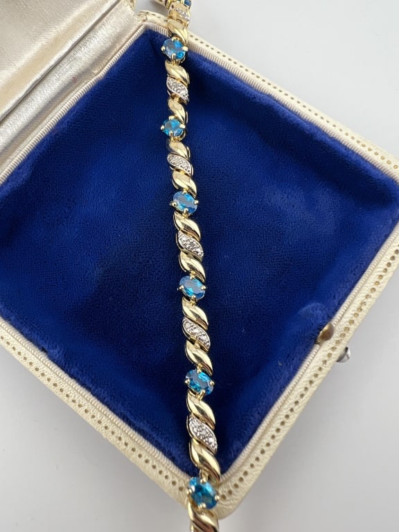 Gold Sterling Aquamarine Diamond Tennis Bracelet: Gold Over Sterling Silver Aquamarine & Diamond Tennis Bracelet. Gold over sterling silver articulated tennis bracelet with oval aquamarine stones and diamond accents. Stones likely treated or created.