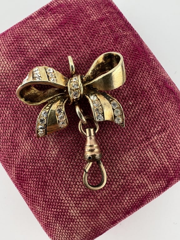 Estate Gold Filled & Paste Bow Pendant w Dog Clip: Estate Gold Filled & Paste Bow Pendant w Dog Clip. Gold plated / gold filled bow motif necklace pendant with paste rhinestone accents and dog clip to hold pendant / charms. Measures 1.5 inches in leng