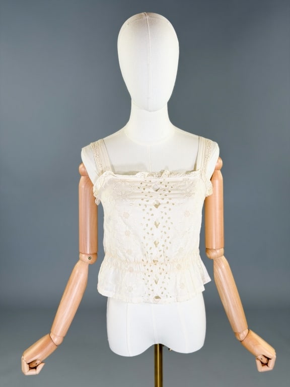 Vintage 1970s Cotton Embroidered Eyelet Lace Top: Vintage 1970s Cotton Embroidered Eyelet Lace Top having embroidery through front with stretched out elastic waist. Measuring 34 inch bust, 26-34 inch waist, 18 inches long. General wear as shown.