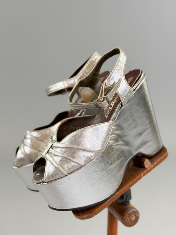 Vintage 1970s Metallic Silver Leather Platforms: Vintage 1970s Metallic Silver Leather Platforms having pleated front peep toe with ankle strap. Labeled size 5.5. Measuring approximately 9.25 inches heel to toe. General wear as shown throughout.