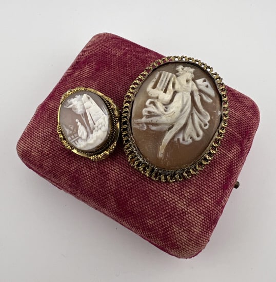 Two Antique Carved Shell Cameo Pendant Brooch Pins: Two Antique Carved Shell Cameo Pendant Brooch Pins. Gold filled or gilt metal settings. Hand carved natural sea shell. One with scene of muse and one with pastoral scene. Measure 1.75 and 1 inch in le