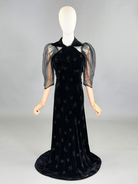 Vintage 1930s Bow Print Velvet Bias Evening Gown: Vintage 1930s Bow Print Velvet Bias Evening Gown having metallic flocked print throughout with sheer sleeves, bias cut with stretch throughout. Measuring 32-36 inch bust, 24-34 inch waist, 57 inches l
