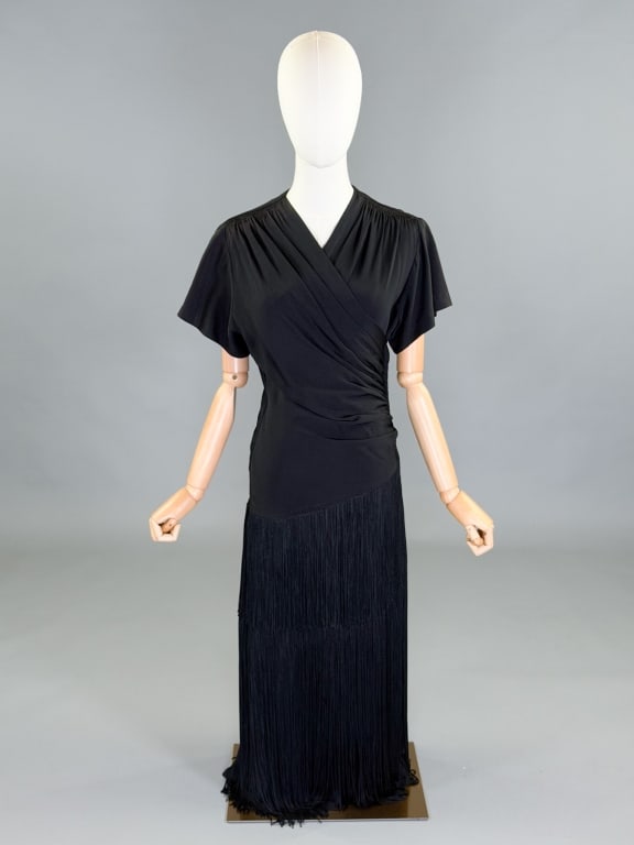 Vintage 1940s Crepe Fringe Draped Dress: Vintage 1940s Crepe Fringe Draped Dress having side and back zip closures. Measuring 32-40 inch bust, 26-34 inch waist, 50 inches long, 7 inch sleeve length. General wear as shown throughout.