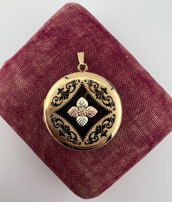Estate Two Tone Gold Filled Floral Motif Locket: Estate Two Tone Gold Filled Floral Motif Locket Necklace Pendant. Hallmarked on the back. Front with flower at center and scrollwork motif. Measures just over 1.5 inches in length with the bail.