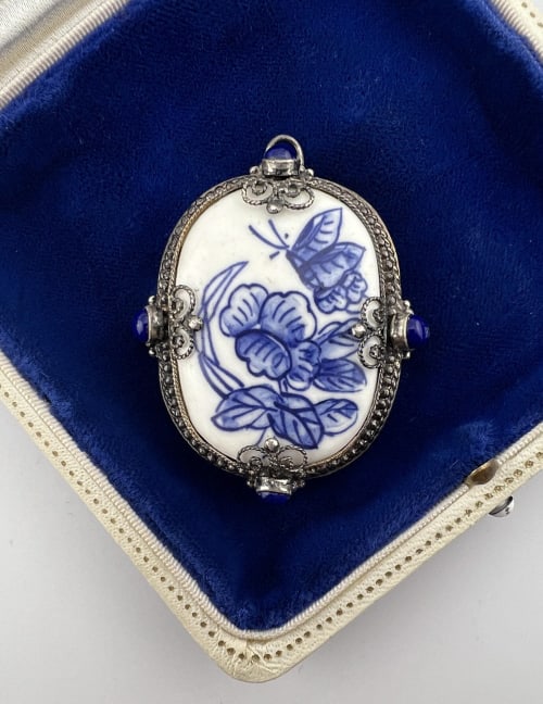 Sterling Lapis Lazuli w Porcelain Fragment Pendant: Sterling Silver, Lapis Lazuli Cabochon, Blue & White Porcelain Fragment Necklace Pendant. With filigree work. Hallmarked on the back. Measures 2 inches in length.
