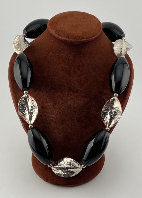 Sterling Silver & Black Onyx Modernist Necklace: Sterling Silver & Black Onyx Modernist Necklace. Having a toggle clasp, can be worn at a few different length. Set with leaf design sterling beads and black onyx beads. Measures 19.5 inches in length.