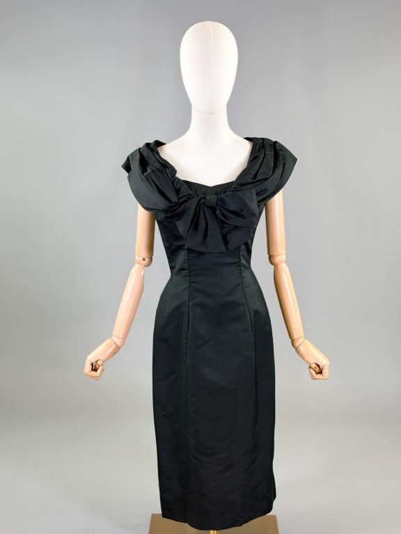 Vintage 1950s Black Silk Faille Bow Cocktail Dress: Vintage 1950s Black Silk Faille Bow Cocktail Dress having bow detail at bust, fitted through body with center back zip closure. Measuring 34 inch bust, 26 inch waist, 43 inches long. General wear thro