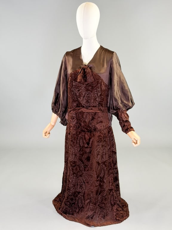 Antique 1920s Devore Silk Velvet Drop Waist Dress: Antique 1920s Devore Silk Velvet Drop Waist Dress having bow detail at neck with Juliet sleeves and belt at waist, side snap closures. Measuring 40 inch bust, 38 inch drop waist, 50 inches long, 23 in