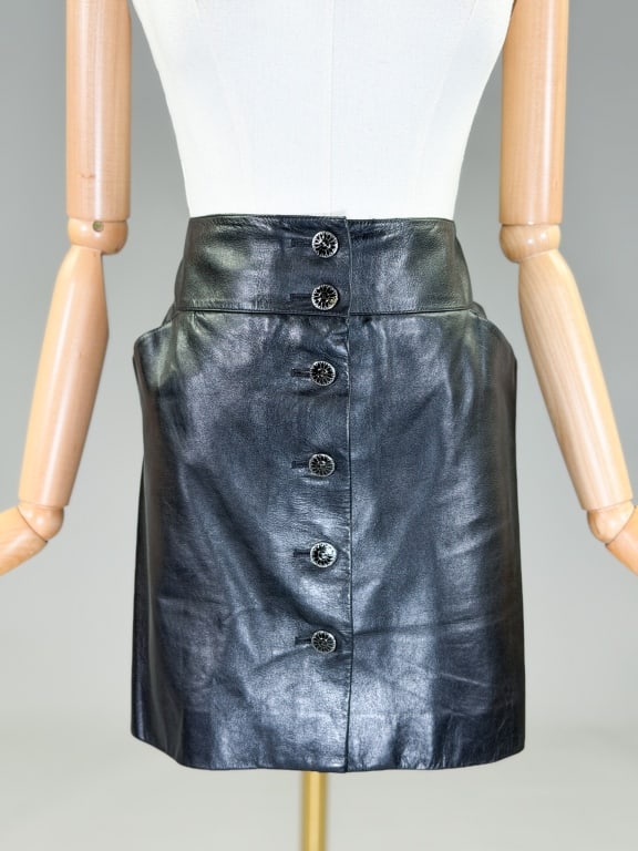 Vintage 2006 Chanel Leather Mini Skirt: Vintage 2006 Chanel Leather Mini Skirt having button front closure, two front and two back pockets. Marked size 42. Measuring 34 inch waist, 16 inches long. From the lifetime collection, fashion archi
