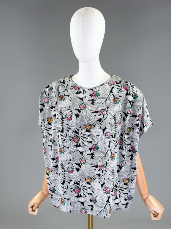 Vintage 1980s Givenchy Floral Print Silk Blouse: Vintage 1980s Givenchy Floral Print Silk Blouse having rounded neckline and pleated shoulders. Labeled Givenchy En Plus, marked size 40. Measuring 64 inch bust, 46 inch waist, 25 inches long, 8 inch s