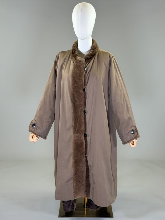 Vintage 1980s Yves Saint Laurent Fur Trench Coat: Vintage 1980s Yves Saint Laurent Fur Lined Trench Coat having fur lining, center front button closure, and two front pockets. Labeled Yves Saint Laurent Fourrures. Measuring 46 inch bust, 42 inches lo