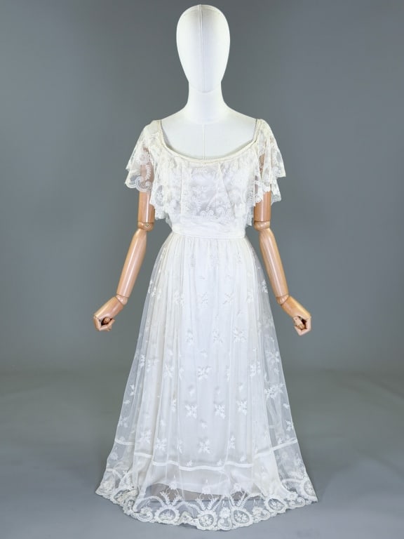 Vintage 1970s Lace Prairie Style Maxi Dress Gown: Vintage 1970s Lace Prairie Style Maxi Dress Gown having lace capelet across bodice with lace skirt and center back zip closure, fully lined throughout. Measuring 34 - 36 inch bust, 25 - 26 inch waist,