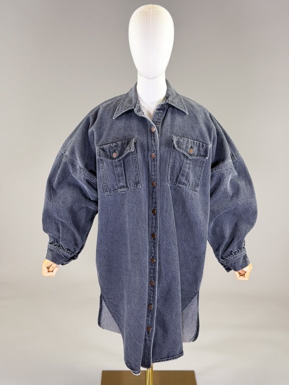 Vintage 1980s Norma Kamali Denim Shirt Dress: Vintage 1980s Norma Kamali Denim Shirt Dress having button front closure with two front buttoned patch pockets. Labeled Norma Kamali - marked size L. Measuring 60 inch bust, 40 inches long, 18 inch sl