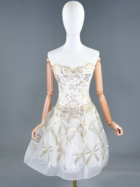 Vintage 1980s Zandra Rhodes Strapless Party Dress: Vintage 1980s Zandra Rhodes Strapless Party Dress having metallic lace covered bodice with bow printed chiffon skirt, closing at center back with zip. Labeled Zandra Rhodes, marked US 6. Measuring 34 