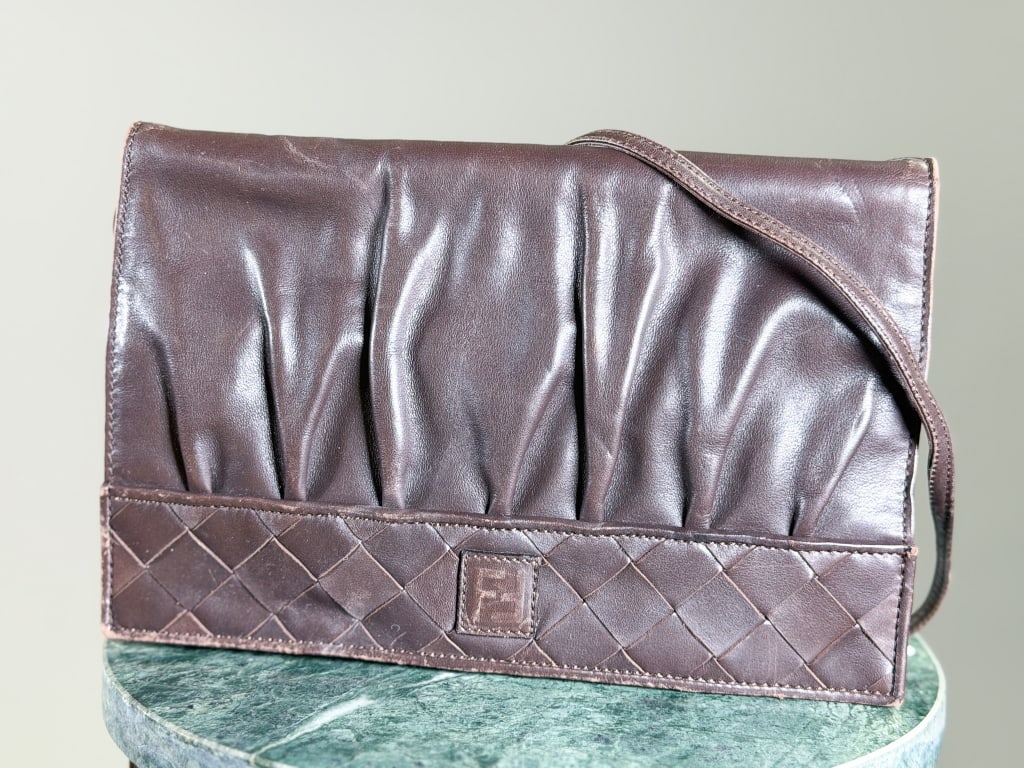 Vintage 1980s Fendi Leather Crossbody Bag: Vintage 1980s Fendi Leather Crossbody Bag having woven leather detail with logo at front and magnetic lock closure. Measuring approximately 6.5 inches high by 10 inches wide by 3 inches deep. Dust bag