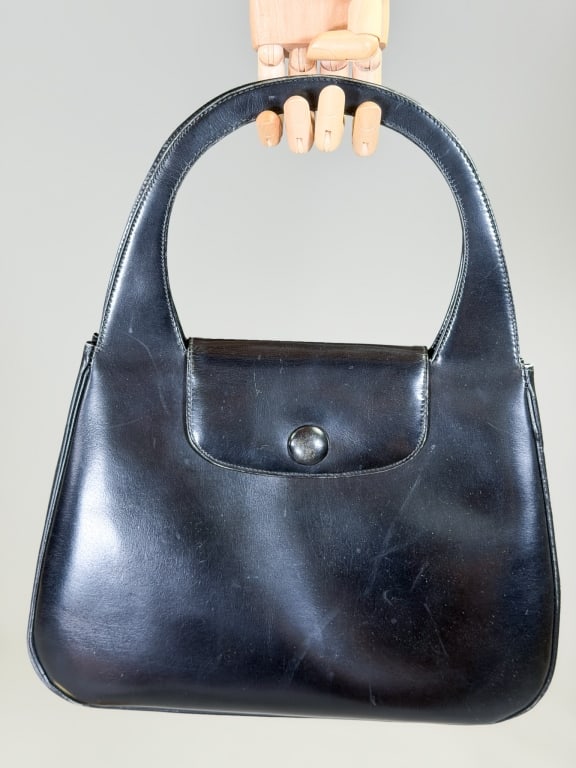 Vintage 1960s Mod Leather Top Handle Purse Bag: Vintage 1960s Mod Leather Top Handle Purse Bag having snap front closure with interior pockets and top handles. Measuring approximately 9 inches high by 12 inches wide by 3 inches deep. From the lifet