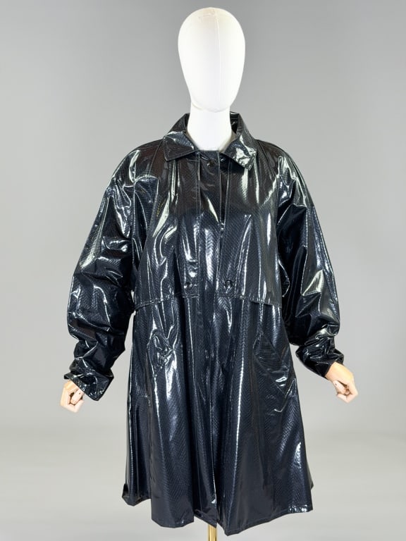 Vintage 1980s Vinyl Snakeskin Print Rain Coat: Vintage 1980s Vinyl Snakeskin Print Rain Coat having snap front closure and front pockets. Marked size Medium. Measuring 54 inch bust, 38 inches long, 24 inches long, 24 inch sleeve length. From the l