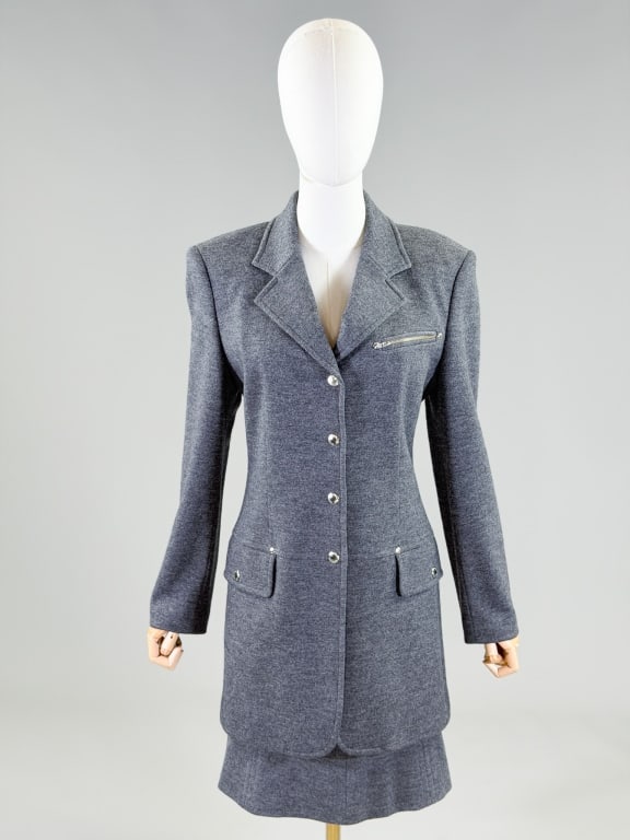 Vintage 1990s Iceberg Wool Skirt Suit Set: Vintage 1990s Iceberg Wool Skirt Suit Set with jacket having snap front closure and front pockets. Marked size 40. Measuring 36 inch bust, 34 inch waist, 33 inches long, 24 inch sleeve length. Skirt w