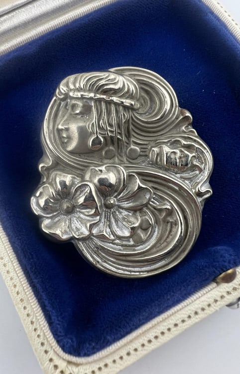 Antique Art Nouveau Sterling Repousse Brooch: Antique Art Nouveau Sterling Silver Repousse Brooch. Portrait of a woman surrounded by flowers. Stamped STERLING on the back. Measures just over 2 inches in length. From the lifetime collection, fashi