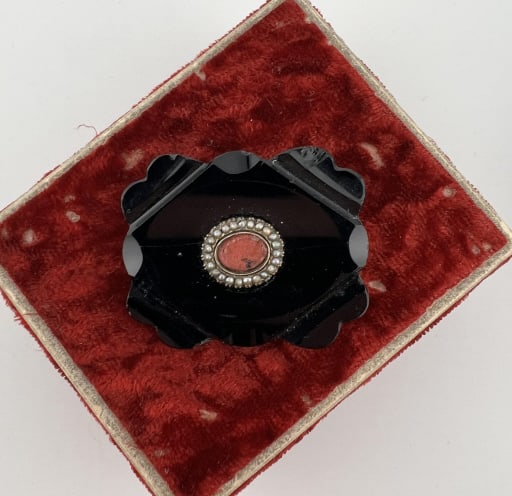 Antique 19th C Mourning Brooch Onyx & Seed Pearls: Antique 19th C Mourning Brooch Onyx & Seed Pearls. Carved black onyx, center panel with seed pearl halo may be a low karat gold. Measures 1.5 inches in length.