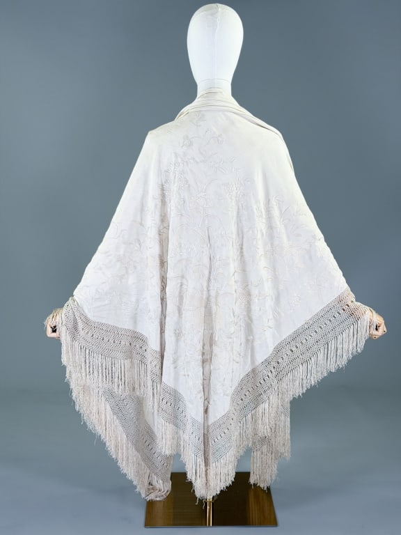 Antique 1920s Chinese Silk Floral Fringe Piano Shawl: Antique 1920s Chinese Silk Floral Fringe Piano Shawl having hand embroidery throughout with macrame fringed edges. Measuring approximately 66 inches by 62 inches inside with 8 inch fringe trim. Genera