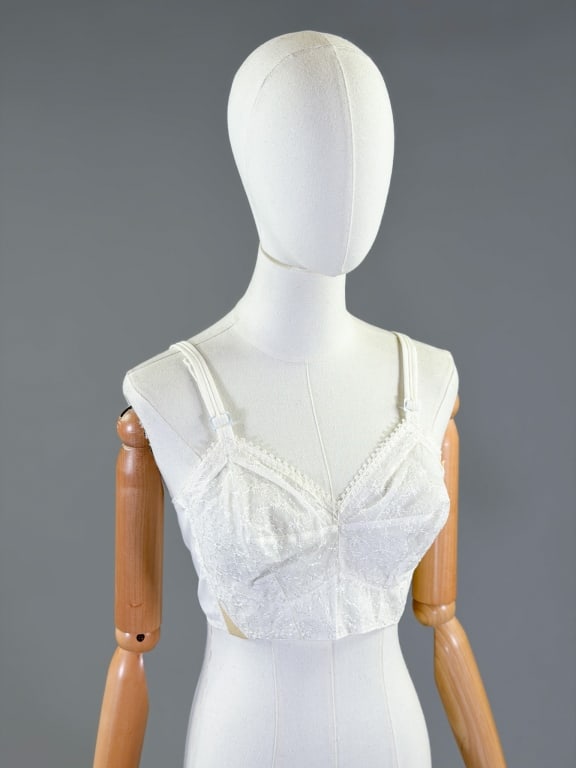 Vintage 1950s Floral Lace Bullet Bra Top: Vintage 1950s Floral Lace Bullet Bra Top having floral embroidery throughout with adjustable shoulder straps and adjustable elastic back. Marked size 34C, with original tag attached. Deadstock unworn 