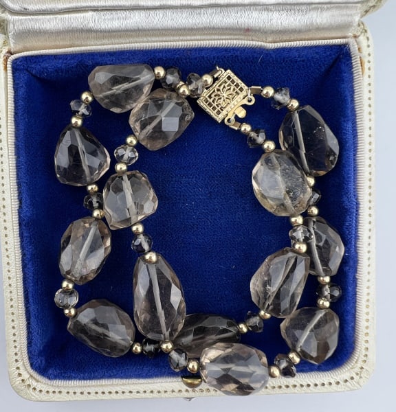 Estate Two Strand 175 Carat Smoky Topaz Bracelet: Estate Two Strand Faceted Smoky Topaz Bracelet. Two strands of briolette faceted smoky topaz beads with gold filled, hallmarked, filigree clasp. Measures 7.5 inches in length. Total carat weight of th