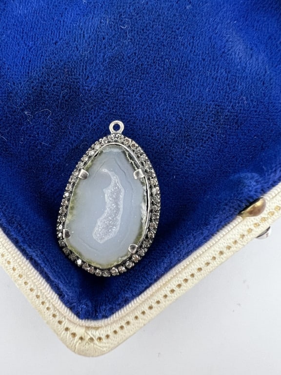 Diamond Halo Druzy Geode Sterling Pendant: Diamond Halo Druzy Geode Sterling Pendant. Sterling silver setting with druzy crystal / geode at center, having a diamond halo surrounding. Measures just over 1.25 inches in length. Stones test as dia