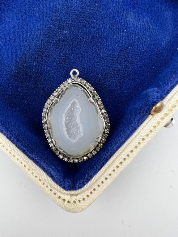 Diamond Halo Druzy Geode Sterling Pendant: Diamond Halo Druzy Geode Sterling Pendant. Sterling silver setting with druzy crystal / geode at center, having a diamond halo surrounding. Measures just over 1.25 inches in length. Stones test as dia