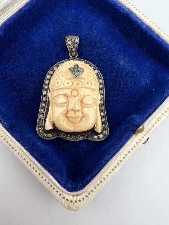 Pave Diamond Set Carved Bone Buddha Pendant: Pave Diamond Set Carved Bone Buddha Pendant. Silver setting mounted with a hand carved bone Buddha head, halo of diamonds surrounding it with additional diamonds on bail and as a headdress ornament. M