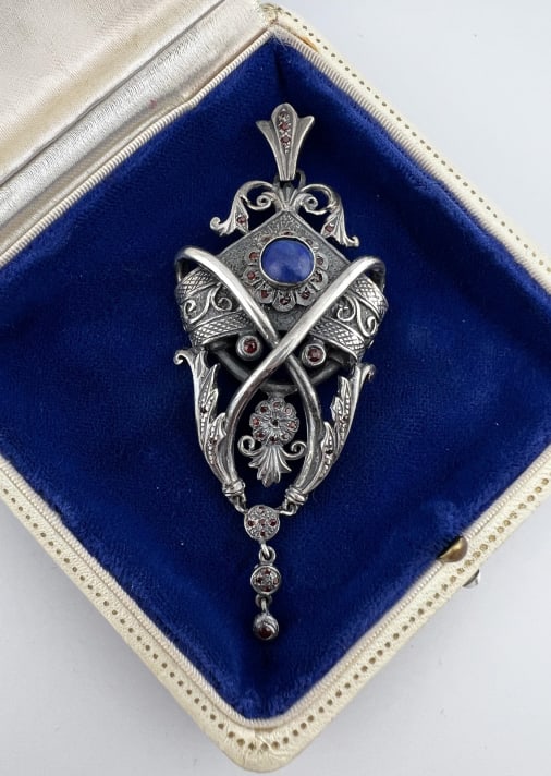 Antique Sterling Renaissance Revival Style Pendant: Antique Sterling Renaissance Revival Style Pendant. Sterling silver necklace pendant with a cabochon lapis lazuli and garnets. Stamped STERLING on the back. Weighs approximately 26 grams total.