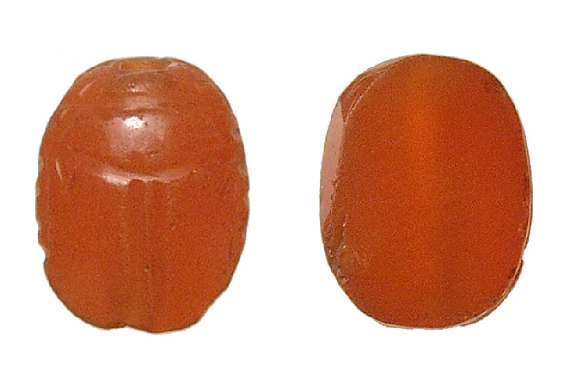 Nice Egyptian carnelian scarab, Middle Kingdom: A nice Egyptian carnelian scarab, Middle Kingdom, c. 2061 - 1690 BC, the body nicely carved with flat base and holed lengthwise for suspension. 12 x 9 mm. Well preserved with nice original polish. Car