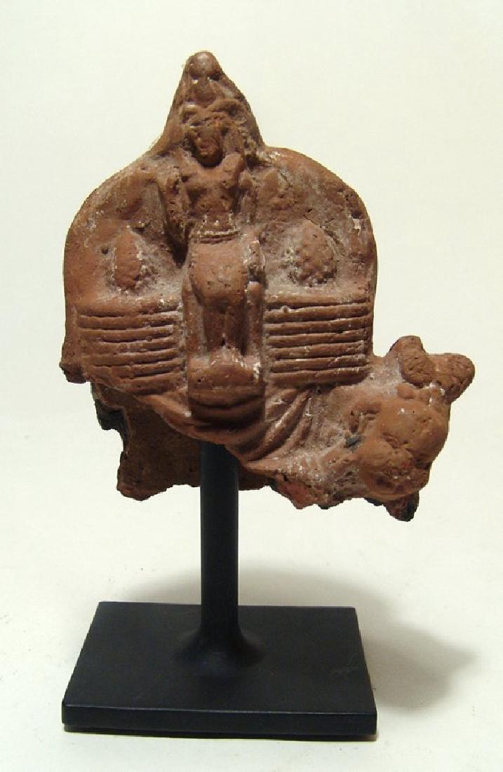 Egyptian terracotta votive depicting seated pharaoh: An Egyptian terracotta votive depicting seated pharaoh, Ptolemaic Period, c. 3rd – 1st Century BC, supported below by Harpokrates, his head wearing a short headdress visible at lower left of the pha