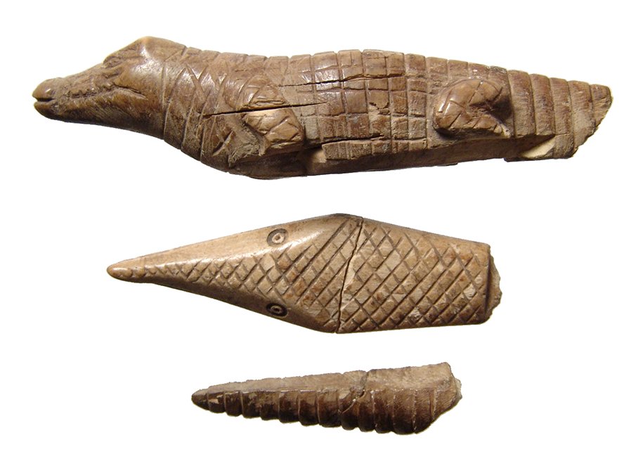 Trio of Egyptian bone crocodilian inlay fragments: A trio of Egyptian bone crocodilian inlay fragments, Roman Period, c. 1st – 5th Century AD, the large depicting the reptile in profile with naturalistic style and great detail, the second the head o