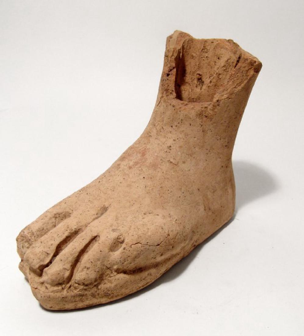 A life-sized Etruscan terracotta left foot: A life-sized Etruscan terracotta left foot, c. 3rd - 2nd Century BC, from a large statue, naturalistically fashioned on an integral base which resembles the sole of a sandal. L: 8 1/3 in (21.1cm), H: 