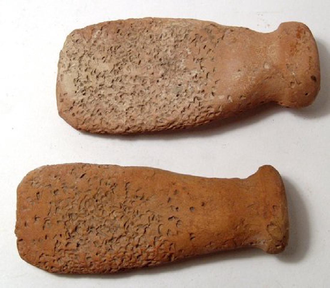 A pair of terracotta graters or fish scalers: A pair of terracotta graters or fish scalers, Near Eastern, 7th - 12th Century, each side flattened and roughened, the handles rolled with a lightly indented end. Both about 5" (12.8 cm). Ex New Jerse