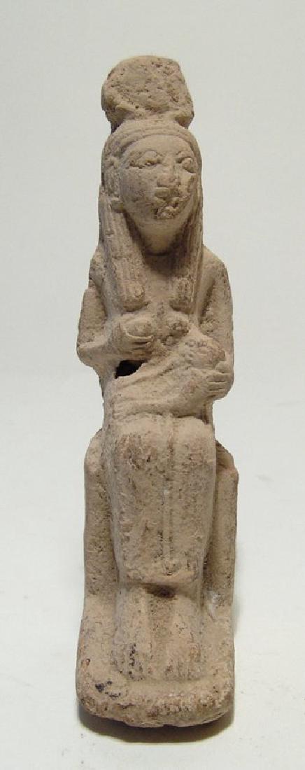An Egyptian stucco figurine of Isis with the child: An Egyptian stucco figurine of Isis with the child Horus, c. 1200 - 332 BC, mold made, the goddess is depicted in classic pose seated on her throne, wearing a long tight-fitting gown and a headdress c