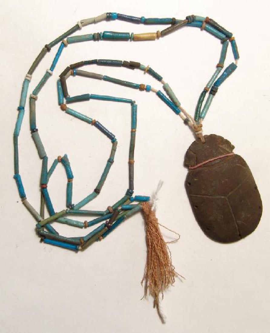 A strand of Egyptian faience beads with scarab pendant: A strand of Egyptian faience beads with scarab pendant, Late Period, c. 664 - 30 BC, the beads are arranged in double-strands of primarily tubular beads with disc spacers, the pendant a scarab which f