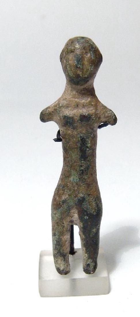 A Levantine bronze female figure: A Levantine bronze female figure, c. 1200 - 600 BC, nude, with bald head, elongated torso and short limbs, her features executed in low relief. H: 2 1/5 in (5.6cm). Ex Birmingham, UK private collectio