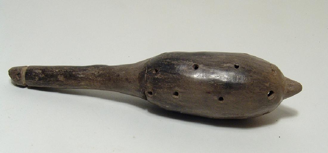 A Jalisco grey-ware rattle, West Mexico: A Jalisco grey-ware rattle, West Mexico, c. 100 BC - AD 250, with long handle and pierced body for sound, the surfaces with nicely burnished slip. L: 6 1/2 in (16.4 cm). Ex Dr. Earl Riddick collection