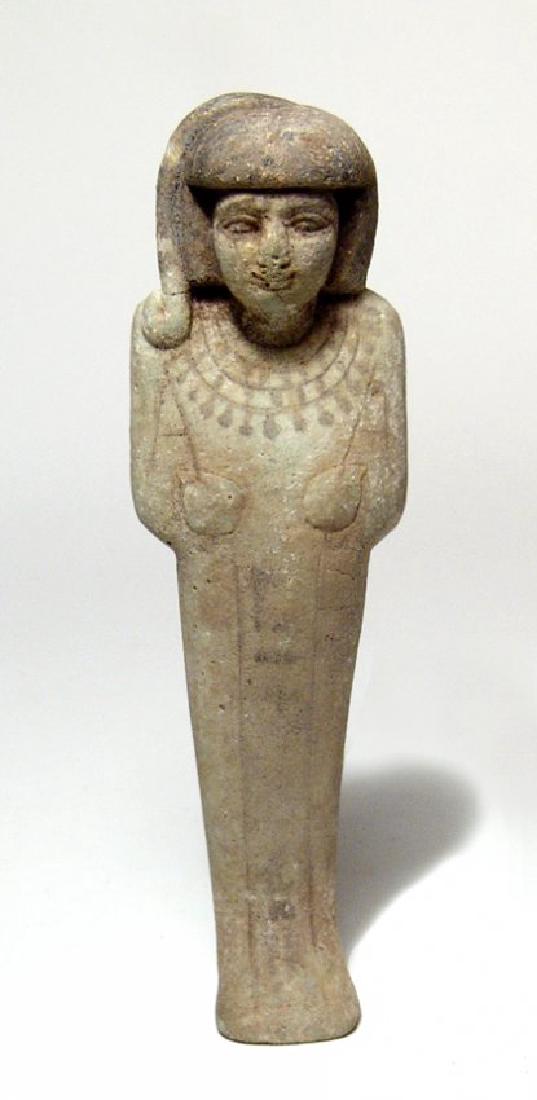 A wonderful Egyptian faience ushabti of rare type: A wonderful Egyptian faience ushabti of rare type, Late New Kingdom, c. 1200 - 1075 BC, mummiform, wearing short wig and broad collar, arms folded across chest, hands holding hoes and a vertical colum
