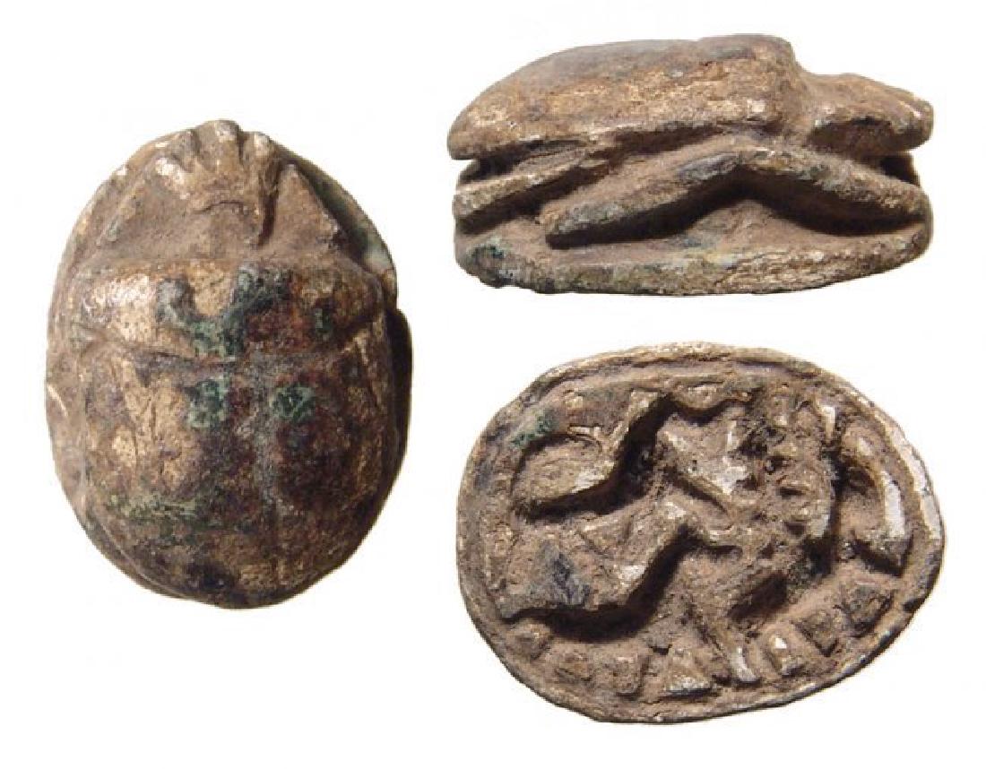 An Egyptian steatite scarab, Late New Kingdom: An Egyptian steatite scarab, Late New Kingdom, 1200 - 1075 BC, the body and legs well-carved, on base, two lions hunting an antelope. 17 x 13 mm. Ex Massachusetts private collection.