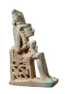 An Egyptian faience amulet of Isis holding child Horus: An Egyptian faience amulet of Isis holding child Horus, Late Period, c. 664 - 30 BC, the goddess sits on a open work throne decorated with uraei with human arms. She wears a headdress consisting of a