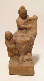 Greek terracotta figurine depicting a seated musician: A Greek terracotta figurine depicting a seated musician, perhaps the Muse Erato, c. 3rd – 2nd Century BC, wearing a long chiton, sitting and playing a kithara which she supports on her lap. A small