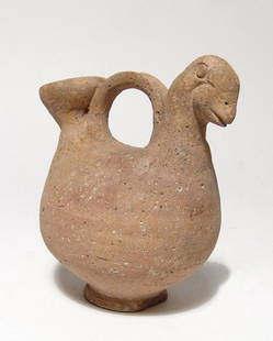 A Near Eastern spouted askos: A Near Eastern spouted askos, c. 1000 – 600 BC, in creme buff, with the head of a goose opposite the flared spout with a small pouring hole at top, looped handle between and the vessel sits on a nar