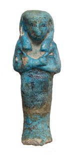 Egyptian bicolor 3rd Intermediate Period ushabti: An Egyptian bicolor 3rd Intermediate Period faience ushabti, 21st Dynasty, c. 1075 - 945 BC, mummiform, wearing tripartite headdress with seshed headband, arms folded at chest, hands holding hoes,