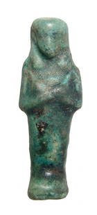 An Egyptian 3rd Intermediate blue-green glazed ushabti: An Egyptian 3rd Intermediate Period blue-green glazed ushabti, 21st Dynasty, c. 1075 - 945 BC, mummiform, wearing tripartite headdress, arms folded at chest. H: 3 3/8 in (8.6 cm). Light deposits,