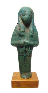 Egyptian green glazed faience ushabti for Un-Nefer: An Egyptian green glazed faience ushabti for Un-Nefer, 3rd Intermediate Period, 21st Dynasty, c. 990 - 969 BC, depicted mummiform, wearing tripartite headdress, arms folded at chest, basket on back;