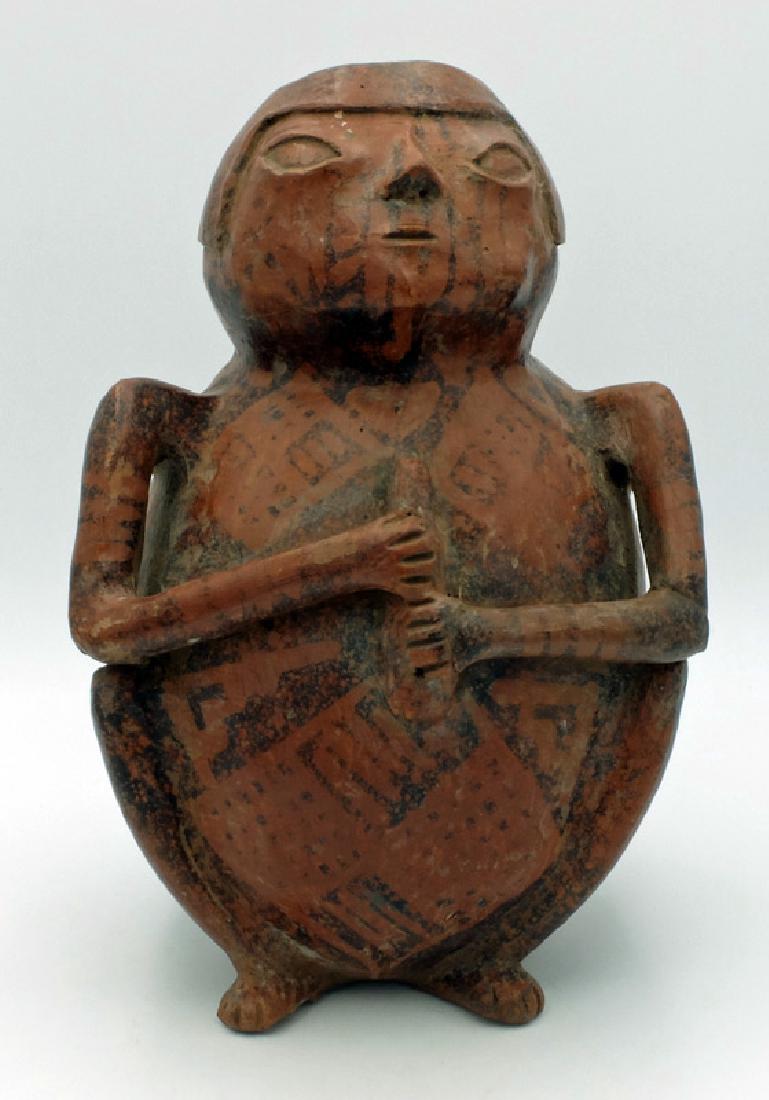 A large Narino figure from the Capuli cultural complex: A large Narino figure from the Capuli cultural complex, c. 850 - 1500 AD, portraying a squatting female holding a flute or snuff tube with both hands. Her legs are modeled in high relief, the arms are