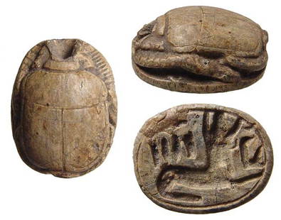 An Egyptian steatite scarab depicting Anubis: An Egyptian steatite scarab depicting Anubis, New Kingdom, c. 1570 - 1075 BC, the legs well-formed and the base depicting Anubis as the guardian of the Necropolis, a small seated deity before. Dimensi